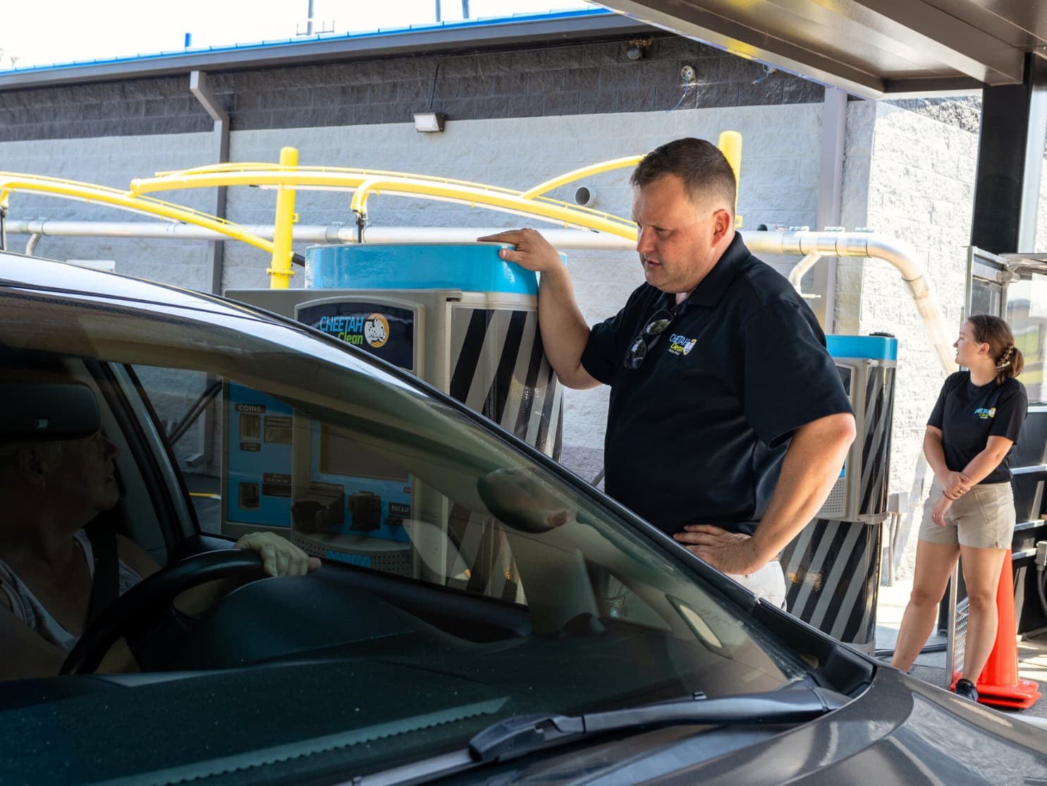 Cheetah Clean team members taking care of a customer at the pay station